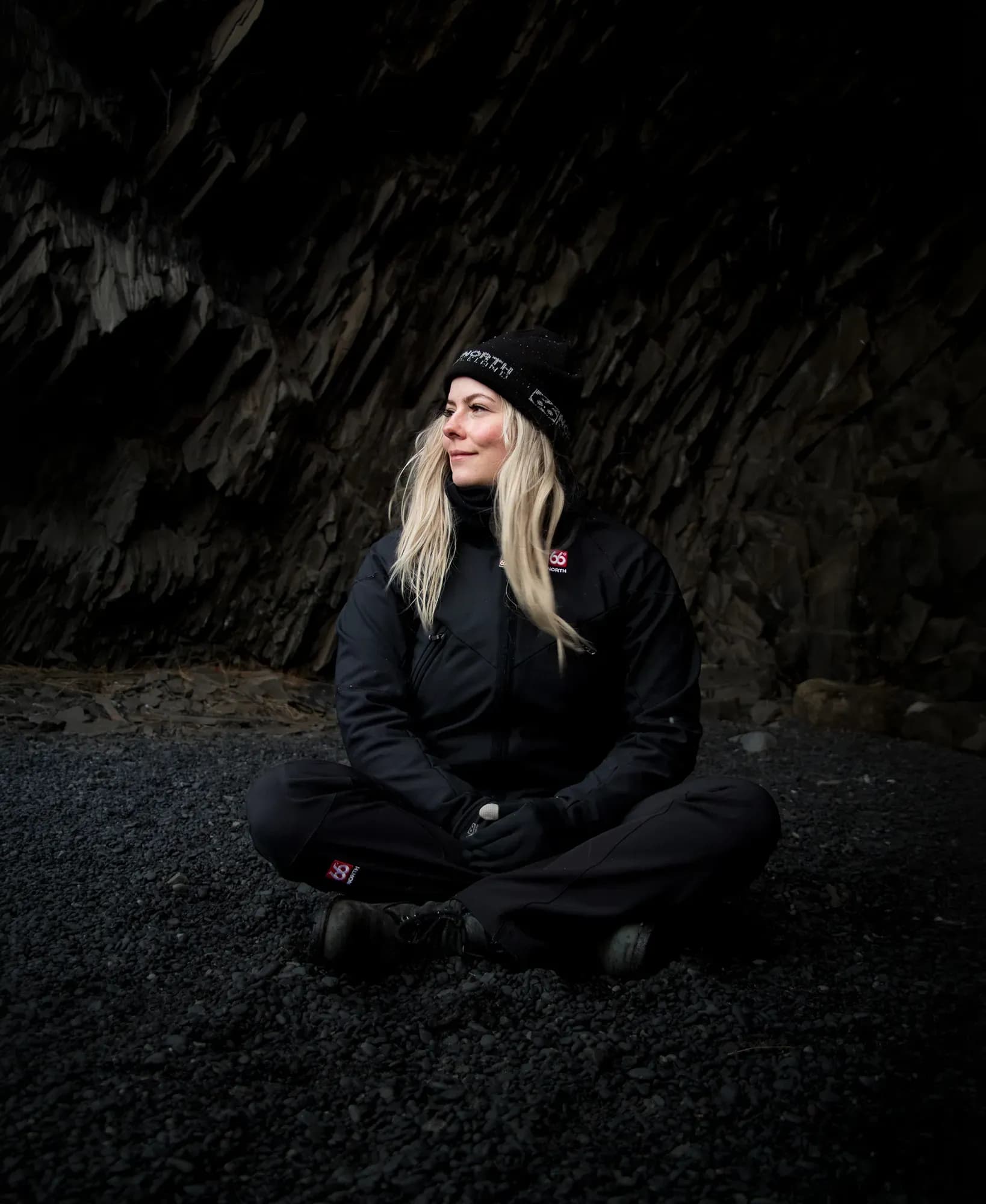 Woman sitting on a black sand beach in Iceland